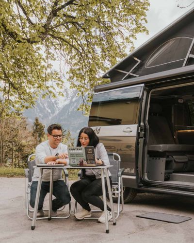 Frustierter junger Mann vor Laptop mit verwirrtem Gesicht, umgeben von Notizzetteln und Farbpaletten.